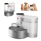 A cat and a dog drinking from the self-refilling water bowl